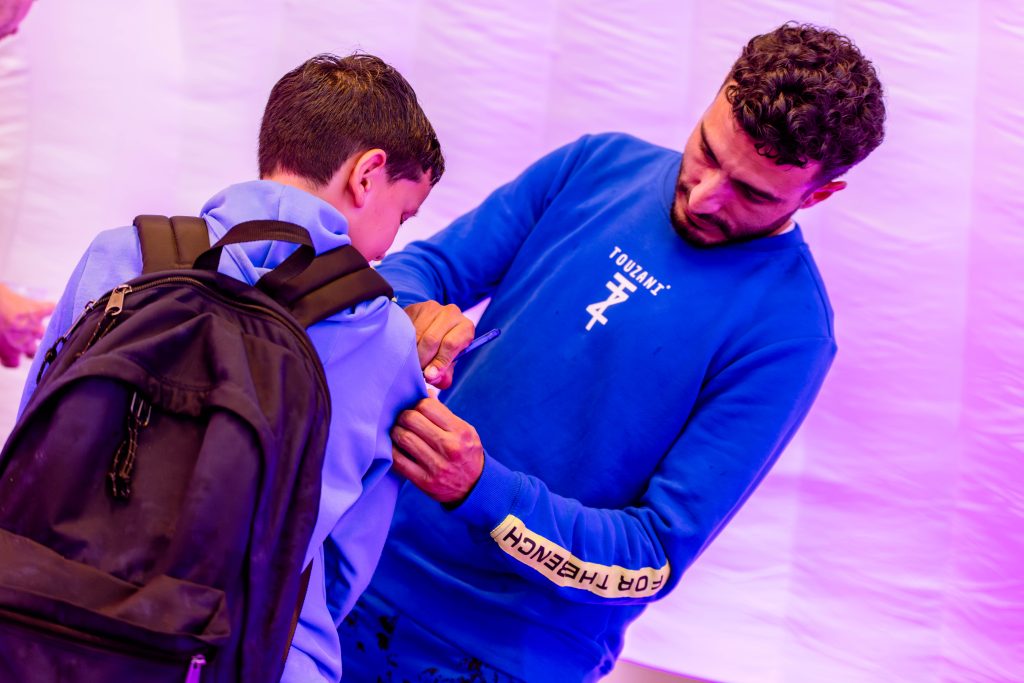 Straatvoetballer Soufiane Touzani zet een handtekening